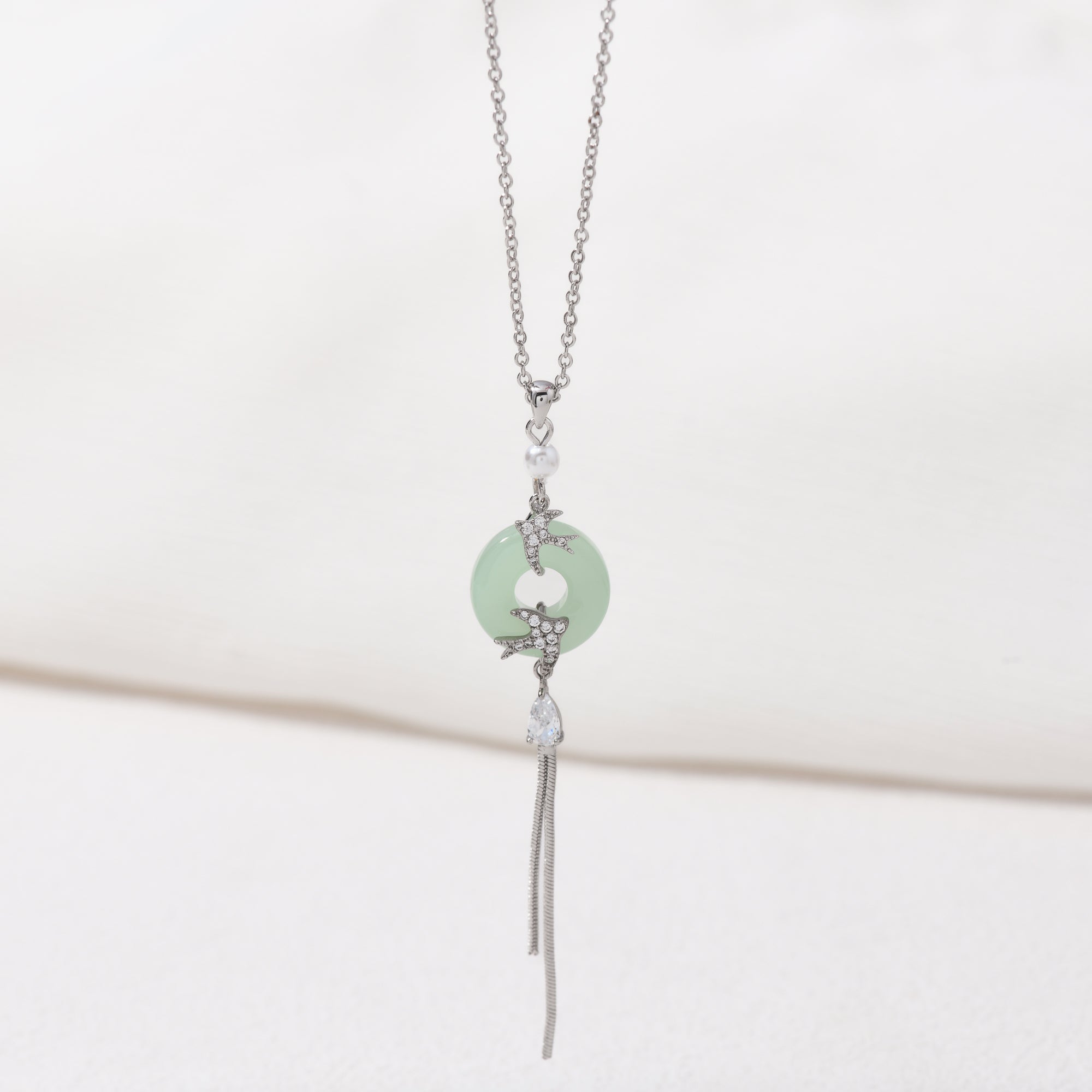 Silver imitation jade bird necklace – on white background